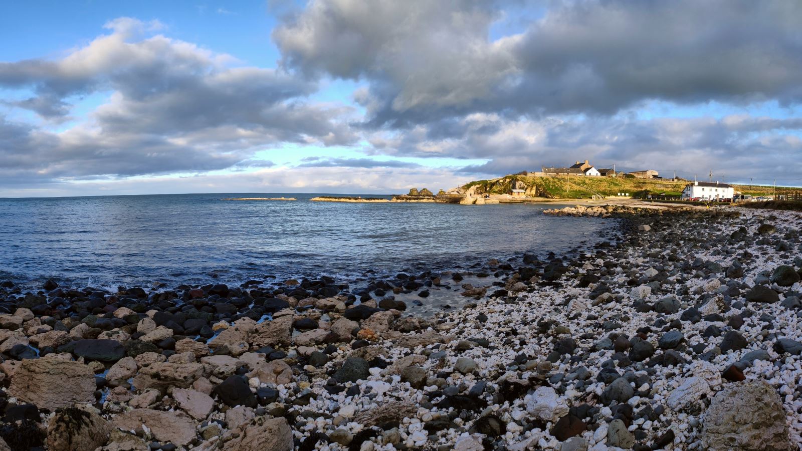 View of Portmuck Harbour showing rocky beach in front of sea